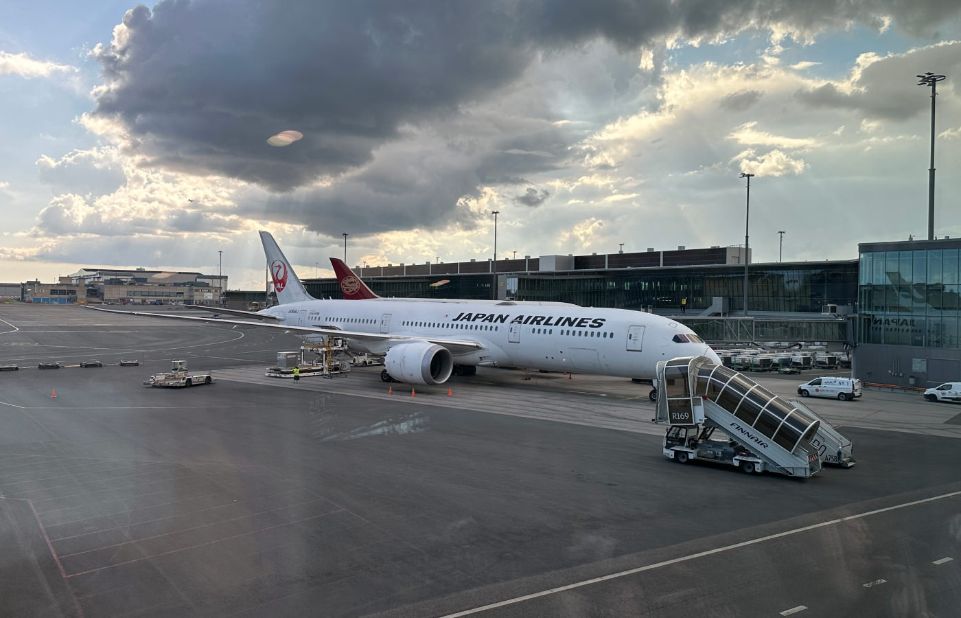 Vitt flygplan med texten Japan Airlines stor på en landningsbana.