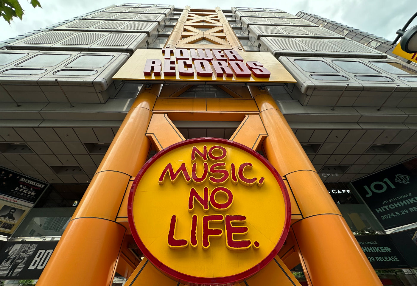 Fasaden framför höghuset och skivaffären Tower Records. En rund skylt lyder "No music, no life".