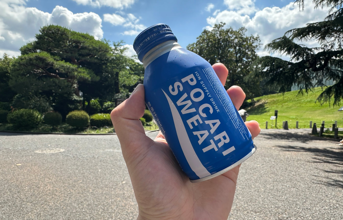 Hand håller i en blå flaska med texten Pocari Sweat.