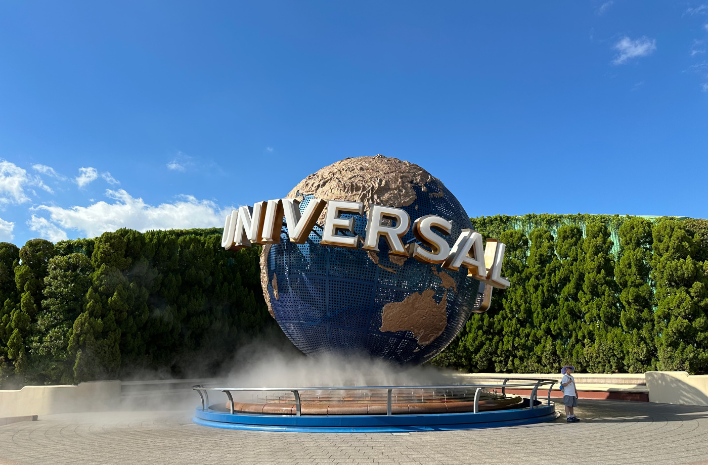 Stor jordglob gjord av metall som snurrar runt i en fontän. Globen har en text som lyder "Universal Studios".